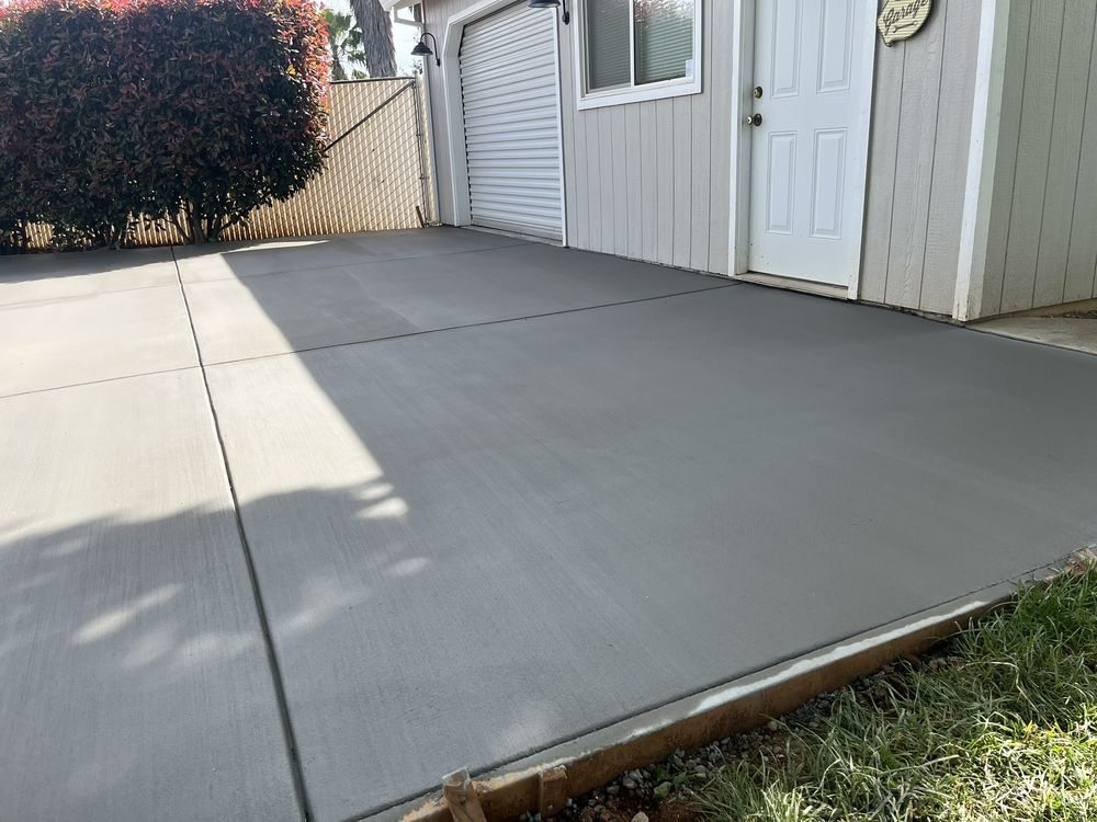 Finished concrete flatwork beside a detached garage